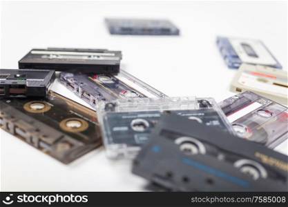 Pile of compact audio cassette tapes on a white background