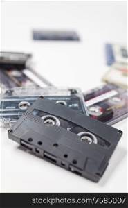 Pile of compact audio music cassette tapes on a white background