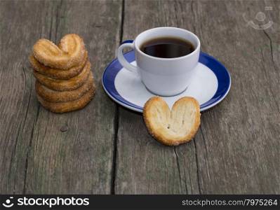 pile of cookies and cup of coffee on a wooden table, a still life on a subject drinks and sweets