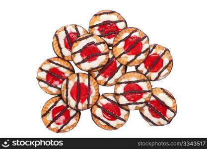 Pile of delicious sweet biscuit cookies with jelly, icing and chocolate on top, isolated on white background.