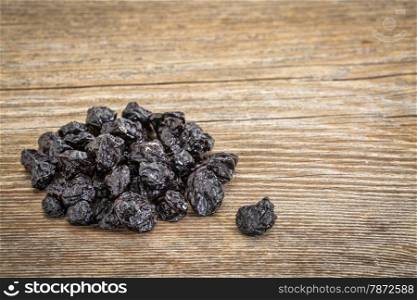 pile of dried blueberry fruit on grained grunge wood background