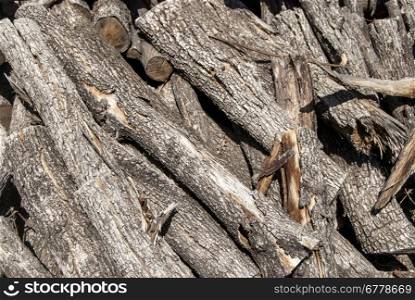 Pile of dry grey firewood as background