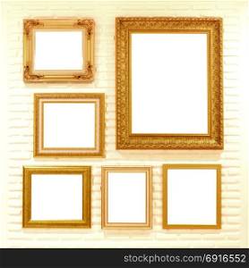 pile of empty golden picture frames on brick wall