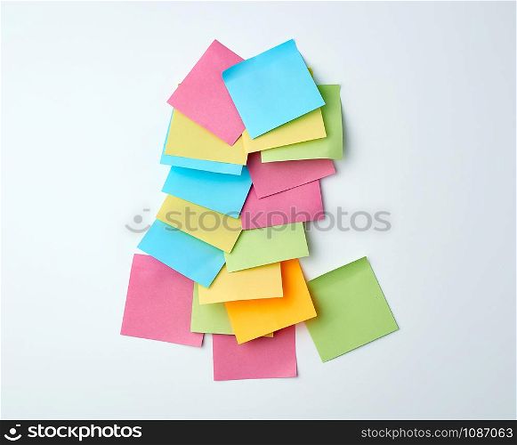 pile of empty multicolored paper square stickers on white background, close up