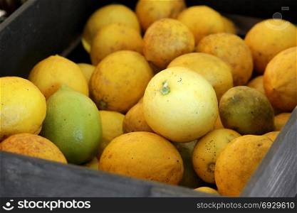 pile of fresh lemons in wooden box