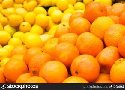 Pile of fresh oranges and lemons at market
