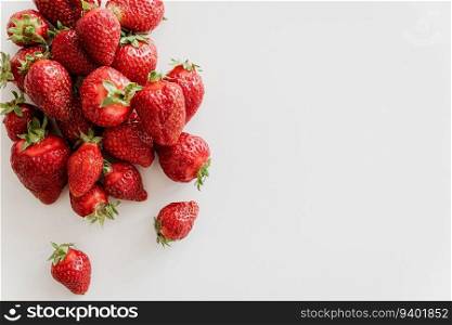 Pile of fresh strawberries on white wooden table. Top view