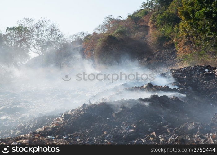 pile of garbage burning white smoke. The air pollution.