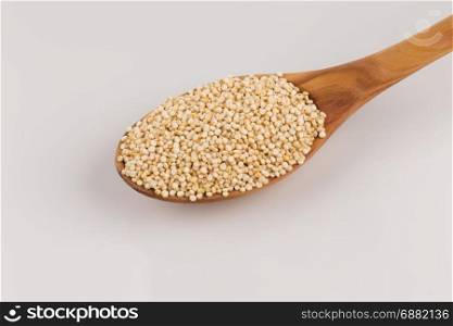 Pile of grain quinoa seeds in spoon isolated over the white background