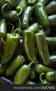 Pile of green jalapeno peppers at produce market.