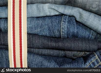 pile of jeans constricted with belt, higly detailed macro shot