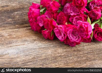 pile of mauvesmall fresh roses on wooden table