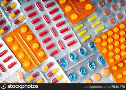 Pile of medical pills and capsules close up background. Pills in plastic package, top view. Concept of healthcare and medicine.. Pile of pills