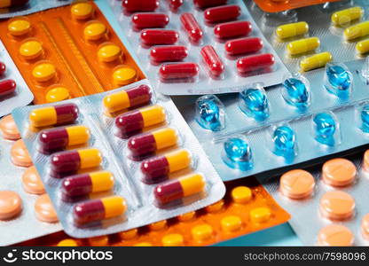 Pile of medical pills and capsules close up macro background. Pills in plastic package. Concept of healthcare and medicine.. Pile of pills