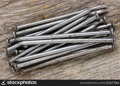 Pile of nails on the wooden background