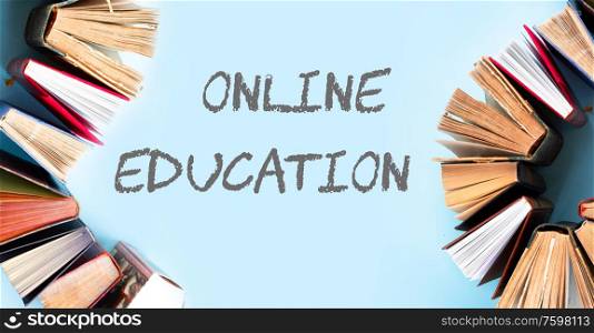 Pile of old books on blue background with online education slogan. Pile of old books