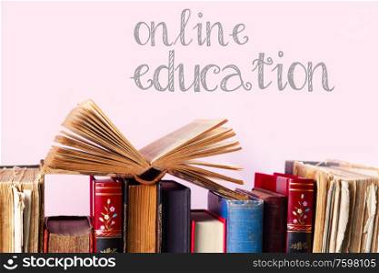 Pile of old books on pink background, online education concept. Pile of old books