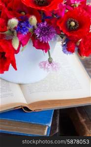 pile of old books. stack of vintage old books on table with field flowers close up