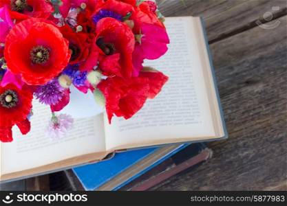 pile of old books. stack of vintage old books on table with field flowers