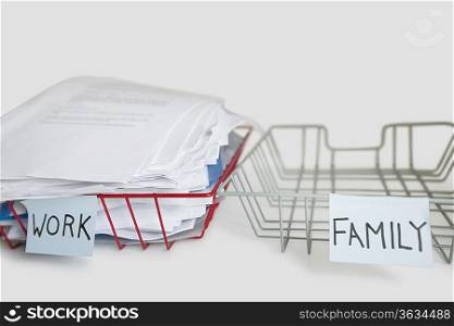 Pile of paperwork in work tray with empty family platter over white background