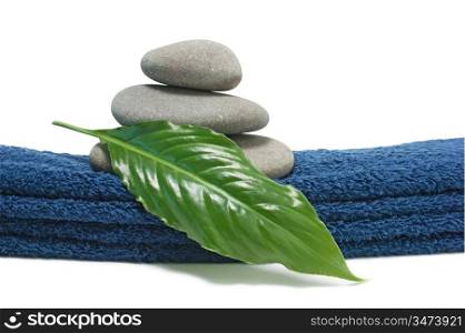 pile of pebbles and green leaves on a towel isolated on white backgrounds