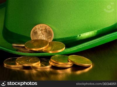 Pile of pure gold coins inside green hat St Patricks Day. Treasure of pure gold eagle coins inside the rim of a green velvet hat to celebrate luck on St Patrick&rsquo;s Day of March 17th. Pile of pure gold coins inside green hat St Patricks Day