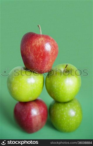 Pile of red and green apples over colored background