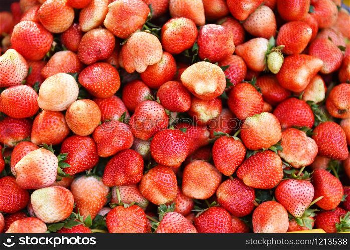 Pile of ripe strawberry for sale in the market fruit / harvested fresh strawberries background texture