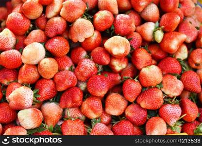 Pile of ripe strawberry for sale in the market fruit / harvested fresh strawberries background texture