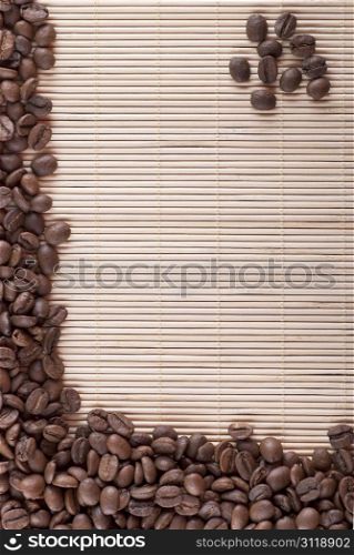 pile of roasted brown coffee beans on bamboo background