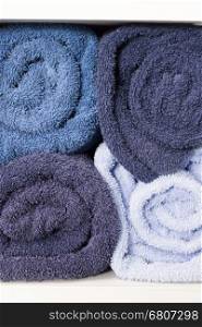 pile of rolling blue towel on white shelf