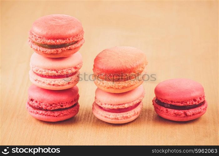 pile of strawberry, raspberry and rhubarb macarons on wooden table