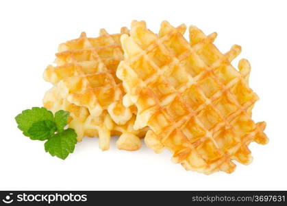 Pile of sweet waffles with green mint leaves isolated on white background.