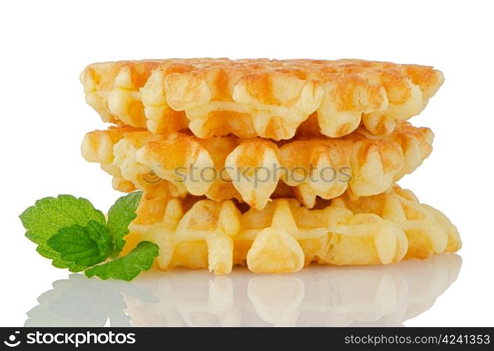 Pile of sweet waffles with green mint leaves isolated on white background.