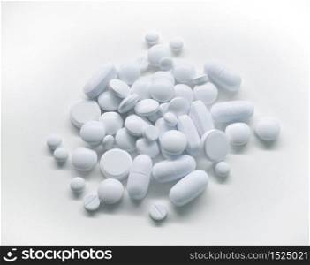 Pile of white medicine pills on light background. White medicine pills
