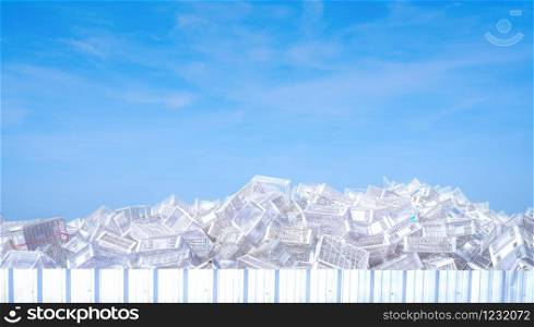 Pile of white plastic basket at factory outdoor warehouse. Many of empty plastic basket against blue sky and white clouds. Basket for store products. Stacked of plastic crates. Cargo and shipping.