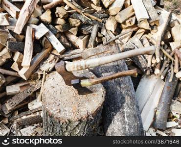 pile of wood, deck for chopping firewood, two axes on village yard
