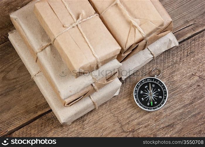 pile parcel wrapped with brown kraft paper and compass
