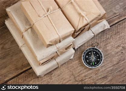 pile parcel wrapped with brown kraft paper and compass