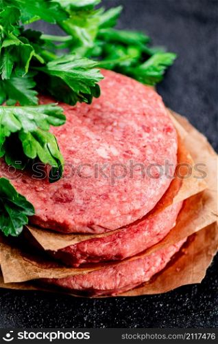 Pile raw burger on the table. On a black background. High quality photo. Pile raw burger on the table.