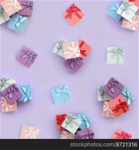Piles of a small colored gift boxes with ribbons lies on a violet background. Minimalism flat lay top view pattern.. Piles of a small colored gift boxes with ribbons lies on a violet background. Minimalism flat lay top view pattern