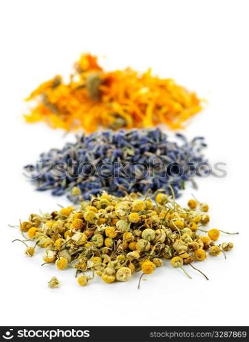 Piles of dried medicinal herbs camomile, lavender, calendula on white background