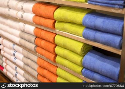 piles of multicolored towels on the shelves