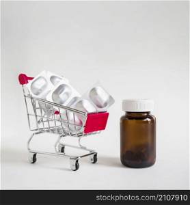 pill blisters shopping cart with glass bottle white background
