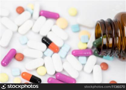 Pill bottle spilling out. colorful pills capsule on to surface tablets on a white background. drug medical healthcare pharmacy concept. pharmaceuticals antibiotics pills medicine in blister packs.