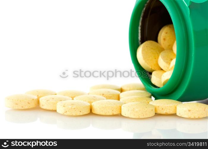 pill bottle with yellow pills on white background