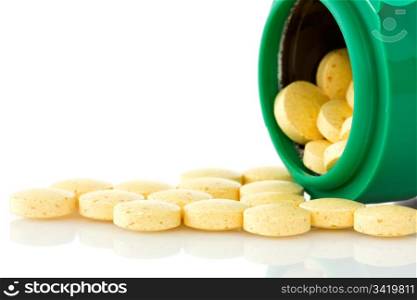 pill bottle with yellow pills on white background