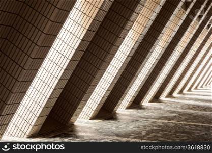Pillars on the outside of the Cultural Center in Hong Kong allow light to illuminate a corridor with alternating bands of lightness and darkness.
