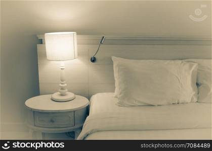 pillow on bed and lamp on bedside table.Warm tones