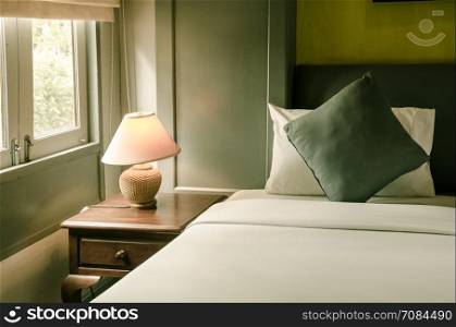 pillow on bed and lamp on bedside table.Warm tones